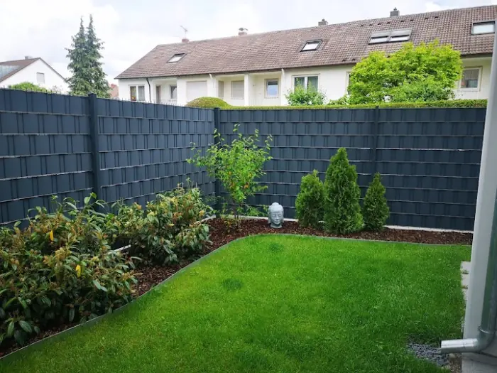 Doppelstabmattenzaun mit Sichtschutzstreifen um einen Rasengarten